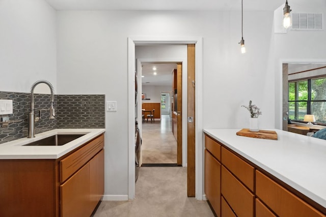 4810 Enchanted Ln, Austin, TX 78745 - kitchen featuring a sink, light countertops, decorative light fixtures, tasteful backsplash, and light colored carpet