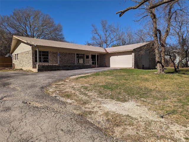 ranch-style house with a garage, driveway, stone siding, and a front yard