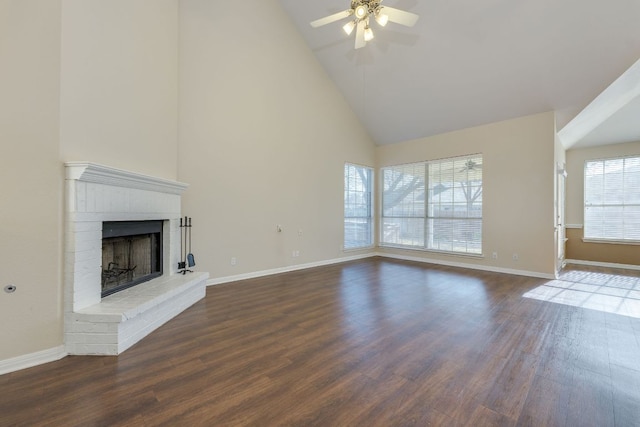 unfurnished living room featuring high vaulted ceiling, a brick fireplace, dark wood finished floors, and baseboards