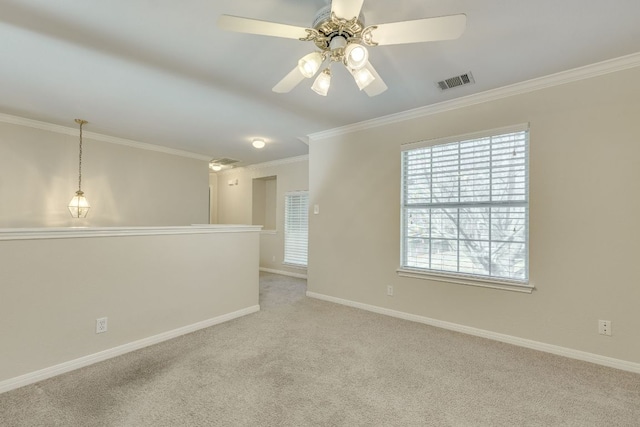 unfurnished room featuring carpet floors, visible vents, crown molding, and baseboards