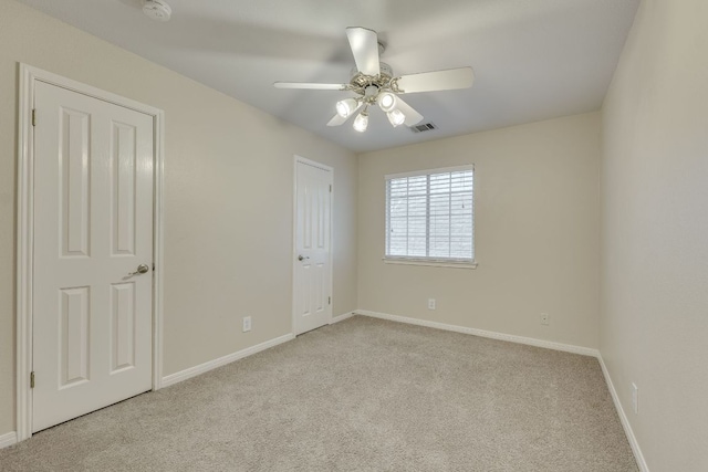 unfurnished bedroom featuring carpet floors, visible vents, baseboards, and a ceiling fan