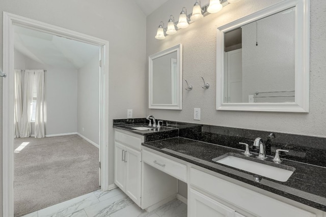 bathroom with marble finish floor, a sink, baseboards, and double vanity