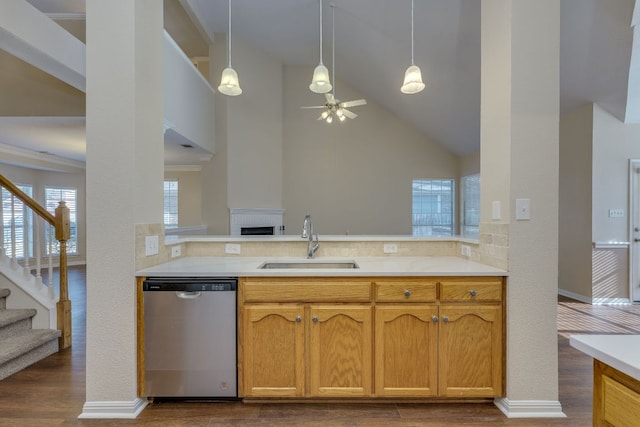 kitchen featuring a peninsula, a sink, light countertops, dishwasher, and dark wood finished floors