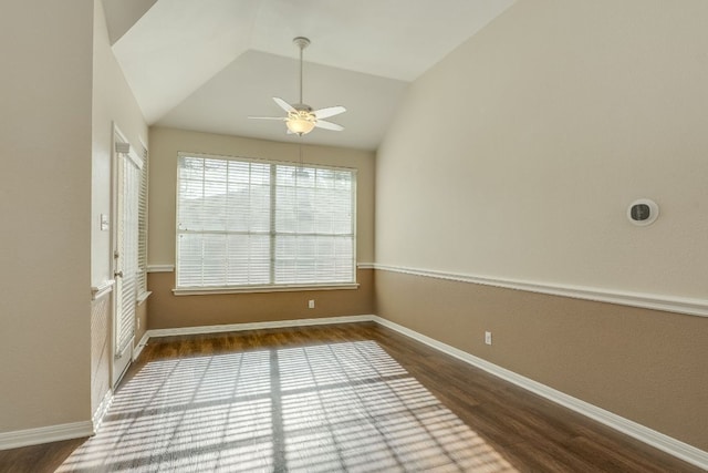 spare room featuring a ceiling fan, vaulted ceiling, baseboards, and wood finished floors