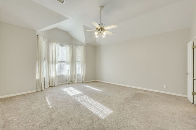 carpeted empty room with visible vents, vaulted ceiling, baseboards, and ceiling fan