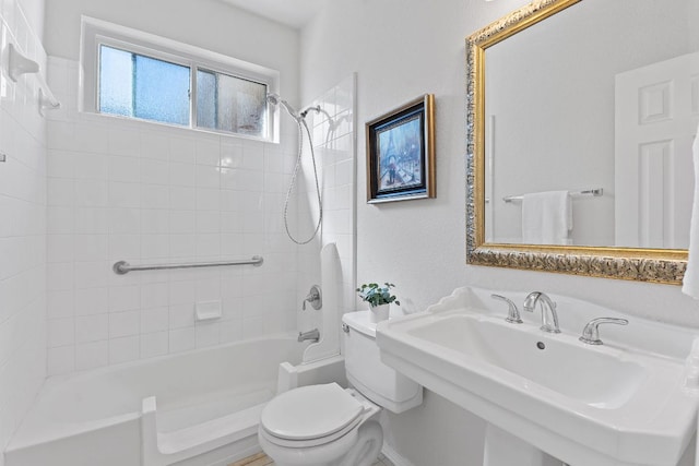 bathroom featuring shower / bath combination, toilet, and a sink