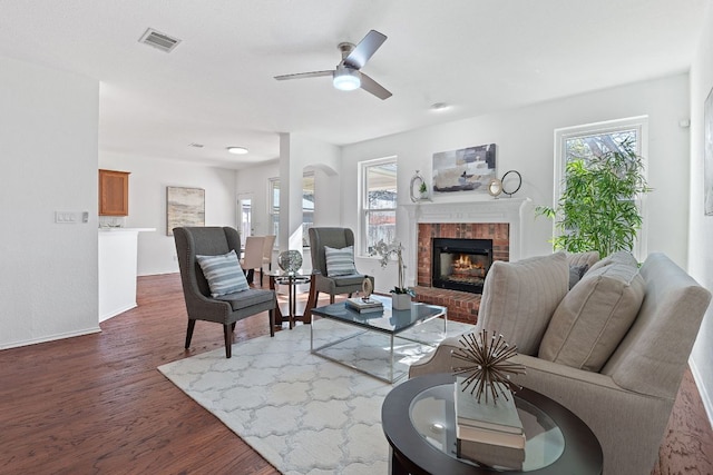 living room with visible vents, a healthy amount of sunlight, dark wood finished floors, and a fireplace