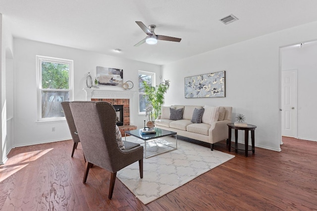 living room with wood finished floors, plenty of natural light, a fireplace, and visible vents