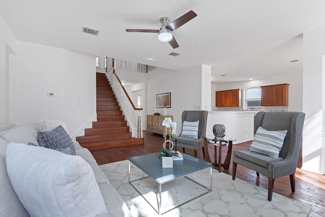 living room featuring stairway, wood finished floors, and visible vents