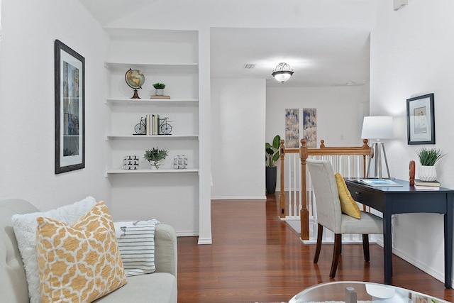 interior space with visible vents, built in shelves, baseboards, and wood finished floors