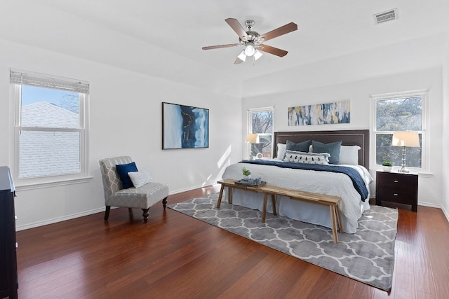 bedroom with visible vents, multiple windows, baseboards, and wood finished floors