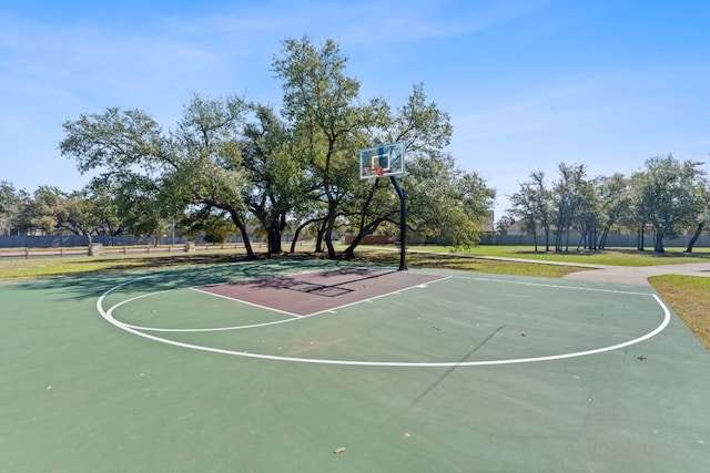 view of basketball court featuring a yard, community basketball court, and fence