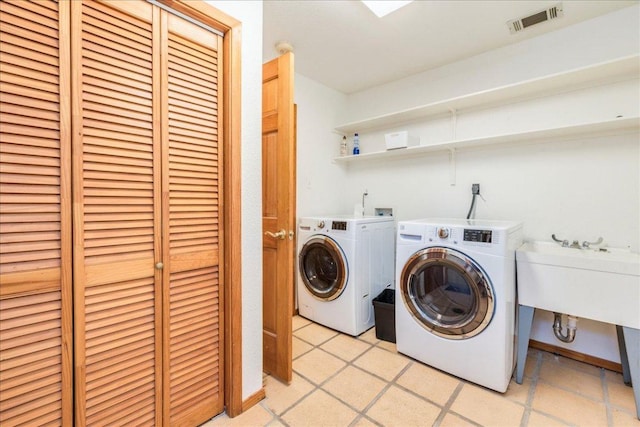 washroom featuring laundry area, separate washer and dryer, and visible vents