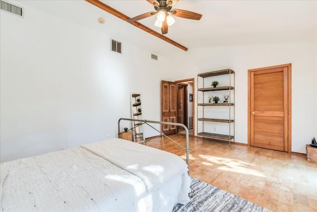 bedroom featuring a ceiling fan, visible vents, and vaulted ceiling with beams