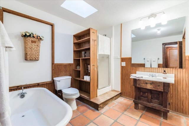 bathroom featuring wood walls, a skylight, a soaking tub, wainscoting, and a stall shower