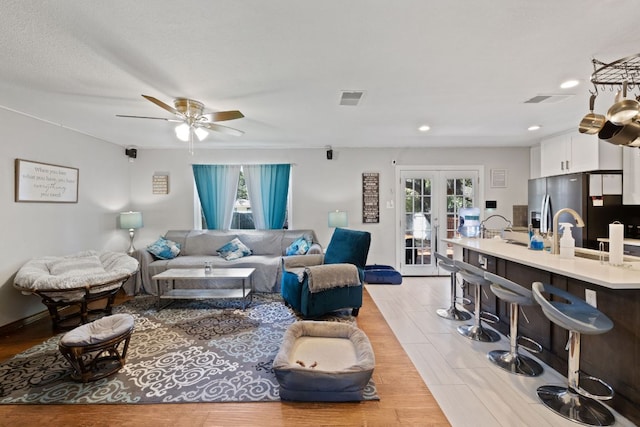 living area featuring a ceiling fan, recessed lighting, french doors, and visible vents