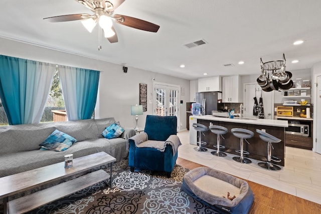 living area with visible vents, recessed lighting, light wood-type flooring, and ceiling fan