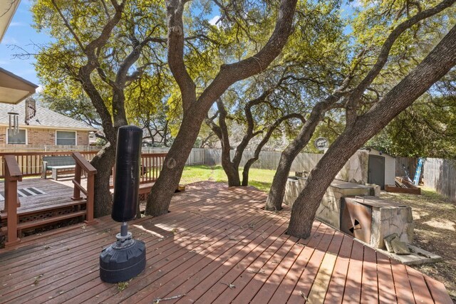 wooden deck with a storage shed, an outdoor structure, and a fenced backyard