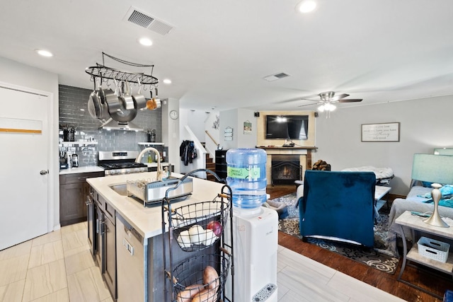 16700 Black Kettle Dr, Leander, TX 78641 - kitchen featuring visible vents, stainless steel range with gas stovetop, a ceiling fan, and backsplash