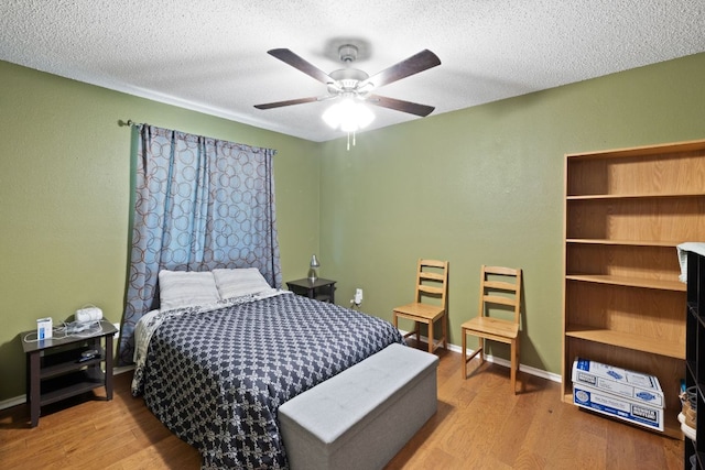 16700 Black Kettle Dr, Leander, TX 78641 - bedroom with a textured ceiling, baseboards, a ceiling fan, and wood finished floors