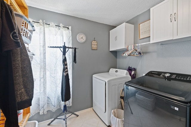 16700 Black Kettle Dr, Leander, TX 78641 - laundry room featuring washing machine and dryer, a textured ceiling, cabinet space, and light tile patterned floors