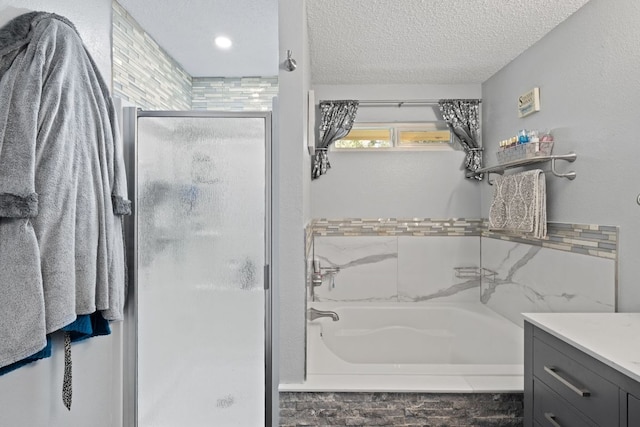 16700 Black Kettle Dr, Leander, TX 78641 - bathroom featuring vanity, a textured ceiling, a tub to relax in, and a shower stall