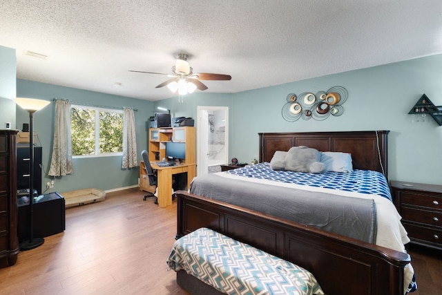 16700 Black Kettle Dr, Leander, TX 78641 - bedroom with ceiling fan, light wood finished floors, visible vents, and a textured ceiling