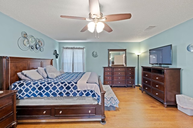 16700 Black Kettle Dr, Leander, TX 78641 - bedroom with ceiling fan, light wood-style flooring, visible vents, and a textured ceiling