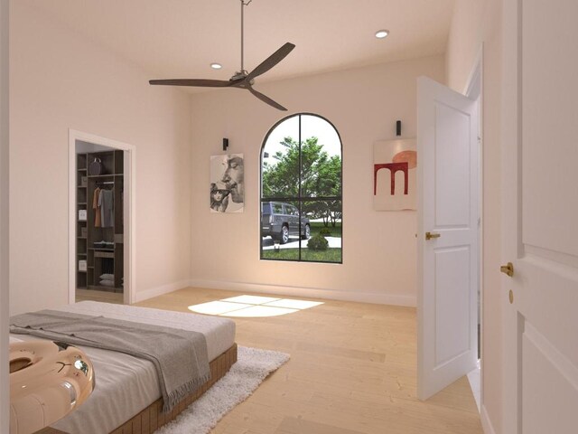 bedroom featuring baseboards, a walk in closet, wood finished floors, and recessed lighting