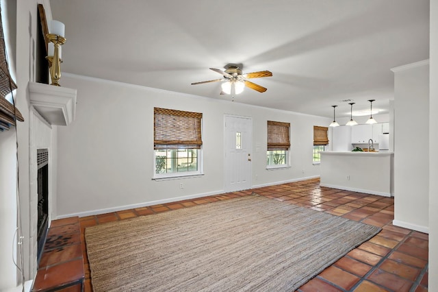 300 Grand Prairie Cir, Dripping Springs, TX 78620 - unfurnished living room with healthy amount of natural light, ornamental molding, ceiling fan, tile patterned floors, and a fireplace