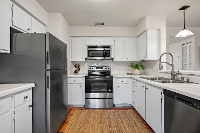 300 Grand Prairie Cir, Dripping Springs, TX 78620 - kitchen with stainless steel appliances, light countertops, white cabinets, tasteful backsplash, and pendant lighting