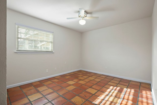 empty room with a ceiling fan and baseboards