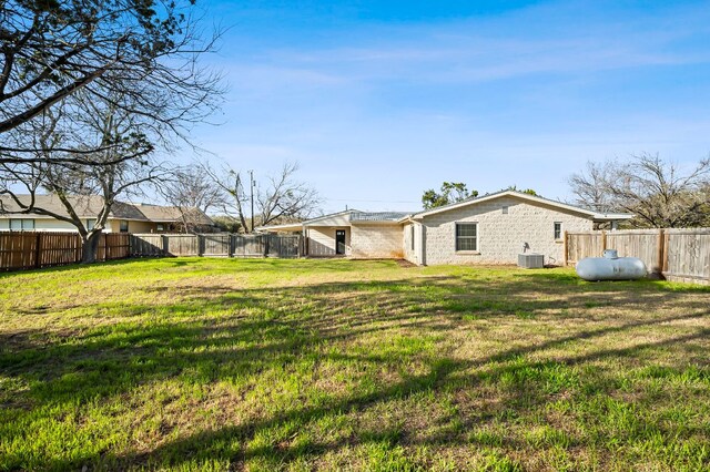 view of yard with a fenced backyard and central AC