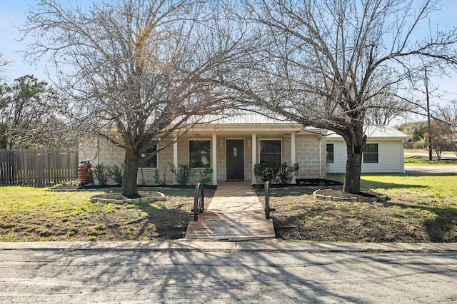 view of front facade featuring a front lawn and fence