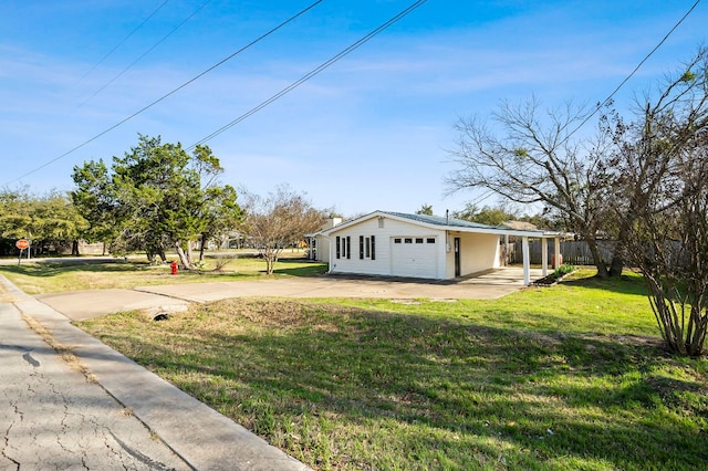 view of yard with a garage and concrete driveway