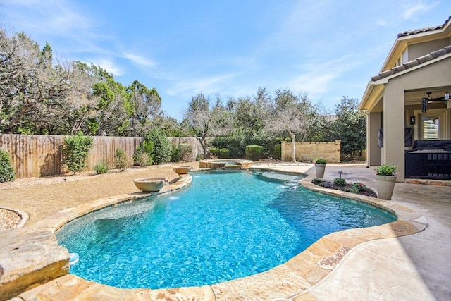 view of swimming pool with a pool with connected hot tub, a fenced backyard, and a patio area