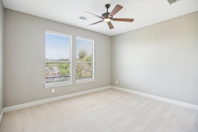 empty room with ceiling fan, baseboards, visible vents, and light carpet