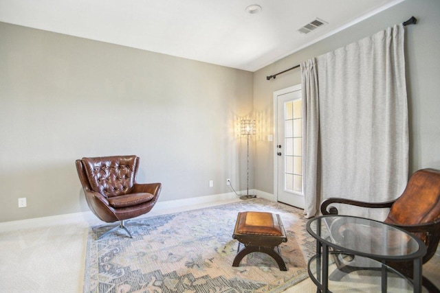 living area featuring visible vents, baseboards, and carpet flooring