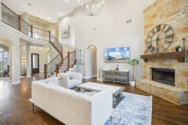 living room with arched walkways, a chandelier, baseboards, and wood finished floors