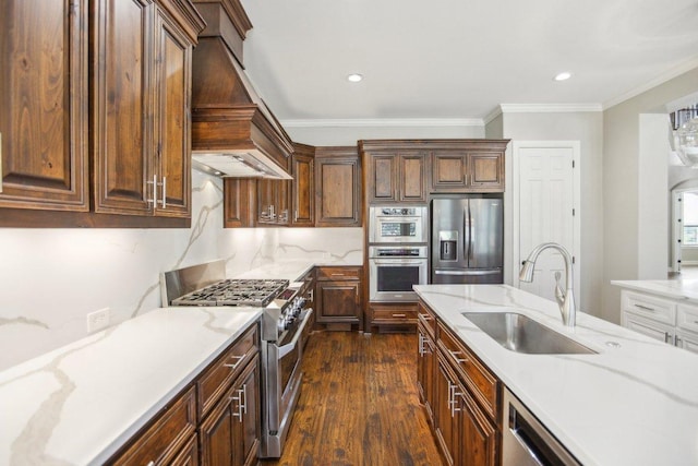 kitchen featuring dark wood finished floors, custom exhaust hood, a sink, appliances with stainless steel finishes, and crown molding