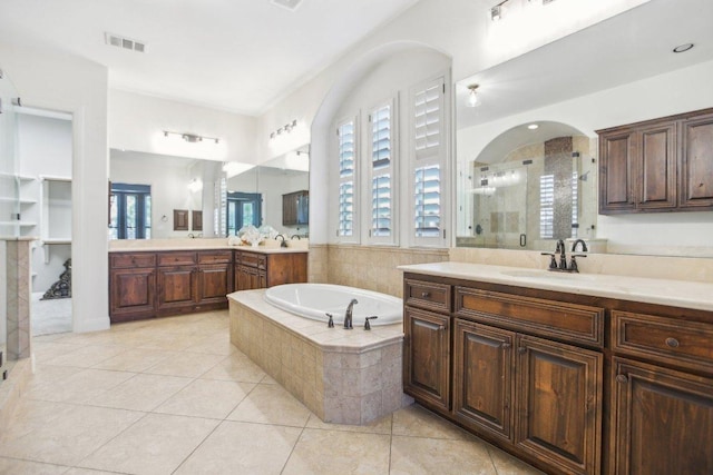 bathroom with visible vents, a shower stall, a garden tub, tile patterned floors, and a sink