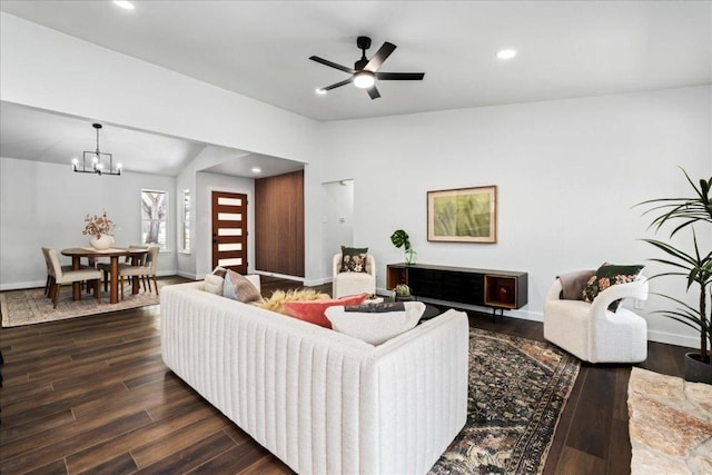 living area with recessed lighting, ceiling fan with notable chandelier, baseboards, vaulted ceiling, and dark wood finished floors