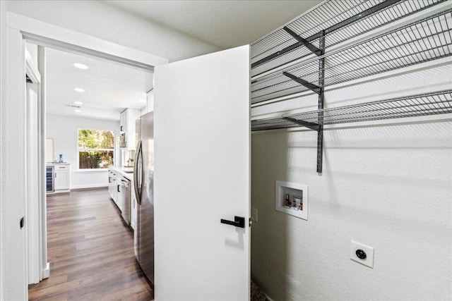 washroom with hookup for an electric dryer, beverage cooler, laundry area, dark wood-style flooring, and washer hookup