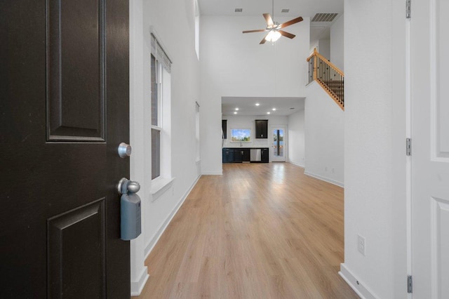 entryway featuring baseboards, ceiling fan, visible vents, and light wood-style floors