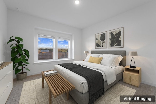 bedroom with light colored carpet and baseboards