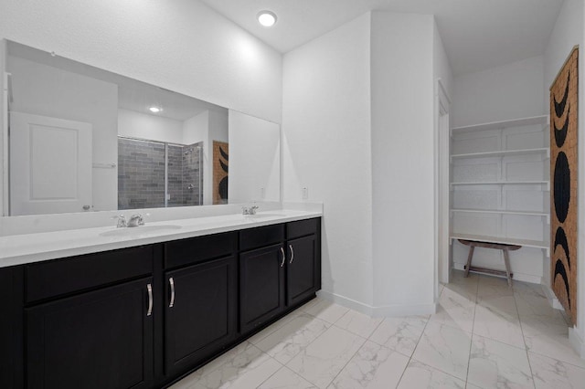 bathroom featuring marble finish floor, double vanity, a stall shower, and a sink