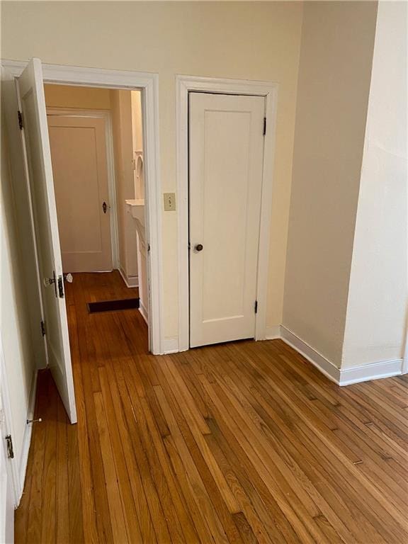 hallway with wood-type flooring and baseboards