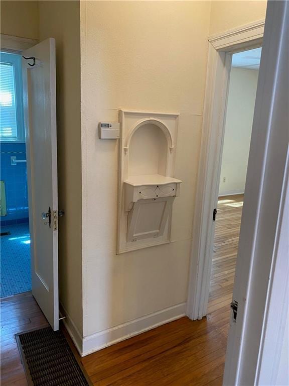 hallway with wood finished floors and baseboards