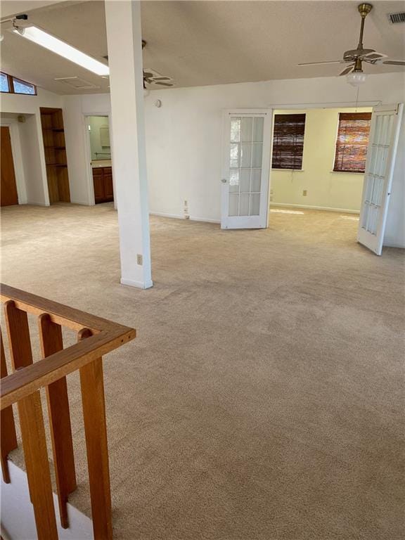 empty room with ceiling fan, light carpet, visible vents, vaulted ceiling, and french doors