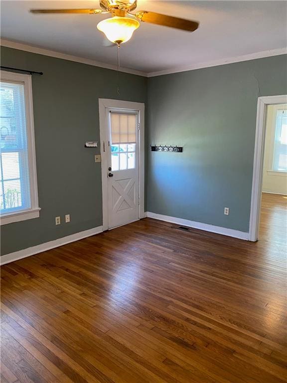 interior space with a healthy amount of sunlight, crown molding, and wood finished floors